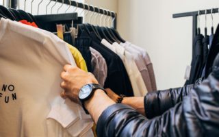 Przeglądanie ubrań na wieszakach w sklepie