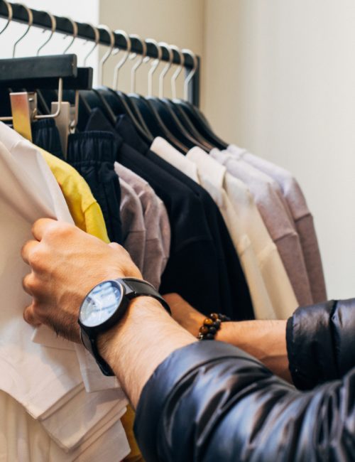Przeglądanie ubrań na wieszakach w sklepie